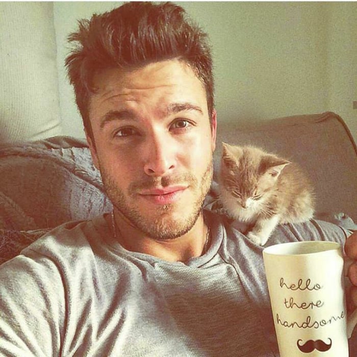 котенок на плече у парня, держащего чашку